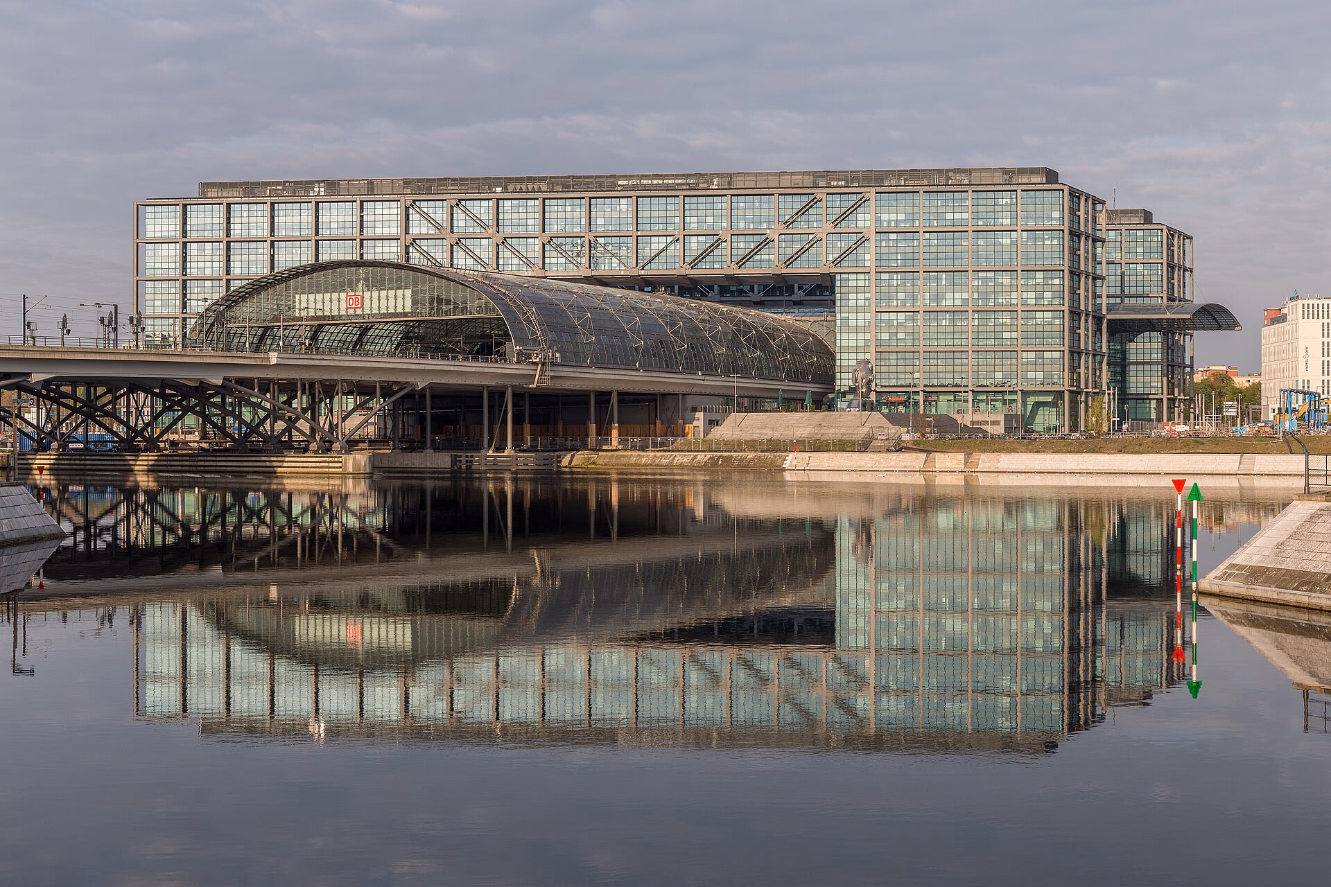 Glasfassade des Berliner Hauptbahnhofs mit Spiegelung im Wasser